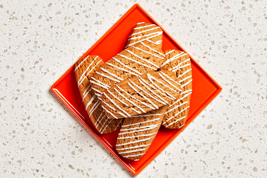 Six rectangular-shaped root beer cookies sitting on a red plate.
