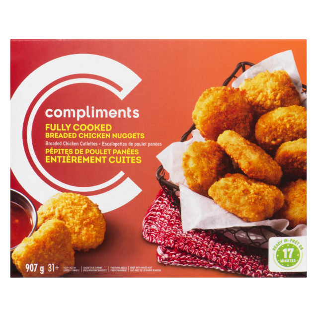 An orange cardboard box of Compliments Fully Cooked Breaded Chicken Nuggets, featuring cooked chicken nuggets in a basket next to a dipping sauce.