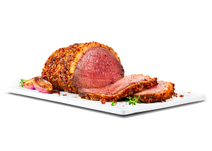 A beef sirloin tip roast royale with two pieces sliced off on a board with herbs and cooked onion